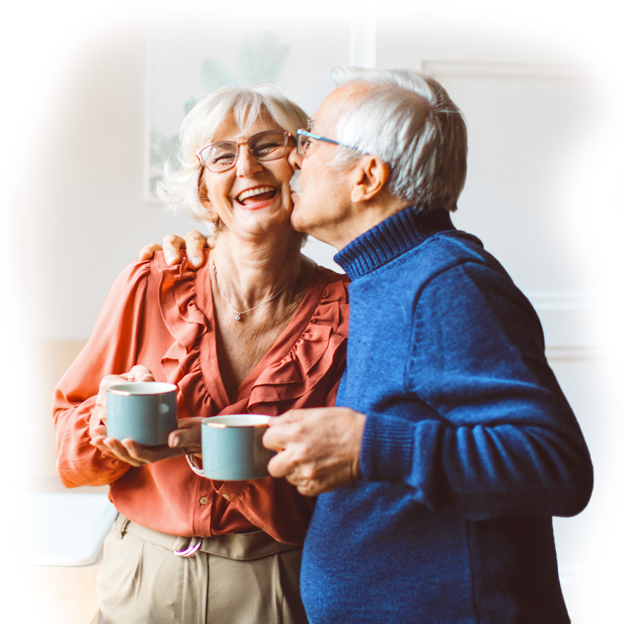 Man kissing woman on the cheek while holding coffee cup