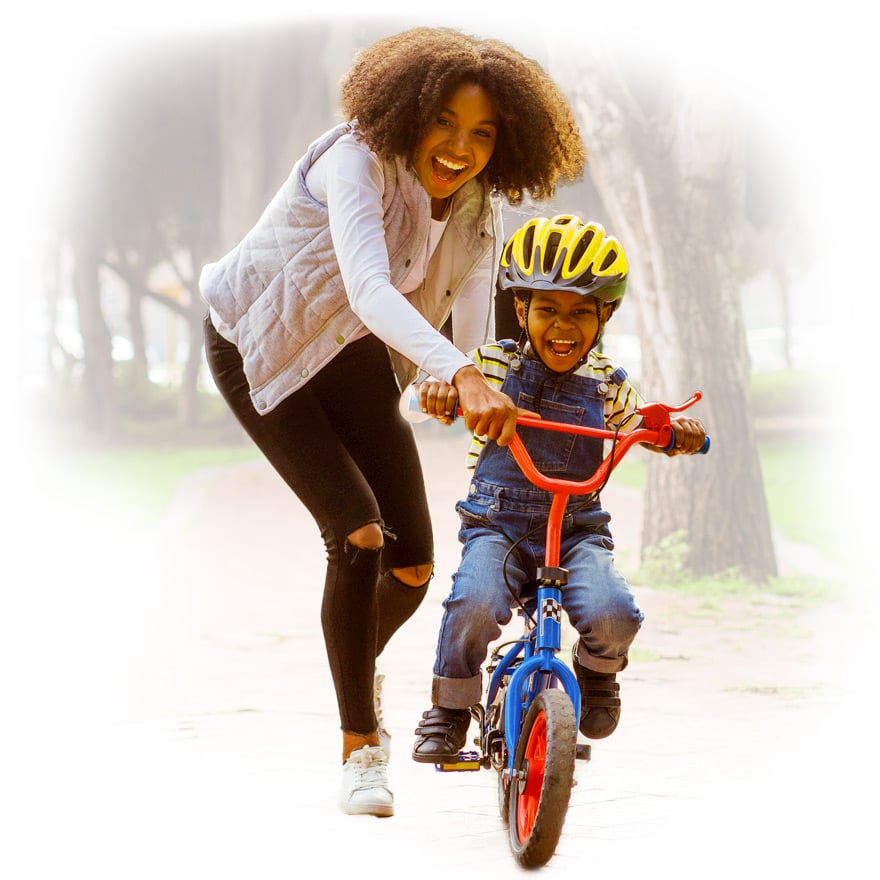 Woman teaching her son how to ride a bike